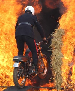 Rider on a motor bike jumping through a ring of fire