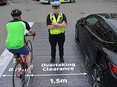 Overtaking clearance is 1.5 meters, Cyclist kirb side, police officer and then car. 