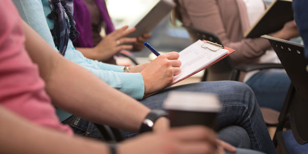 Adults listening and taking notes in a classroom setting